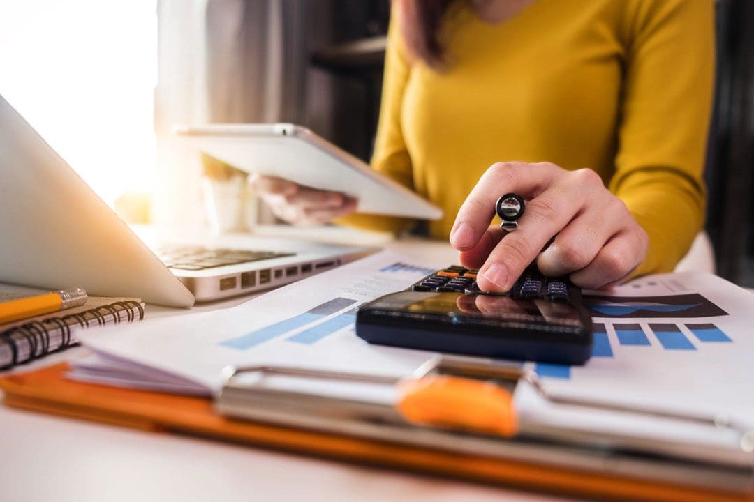 Business women using calculator with computer laptop, Business